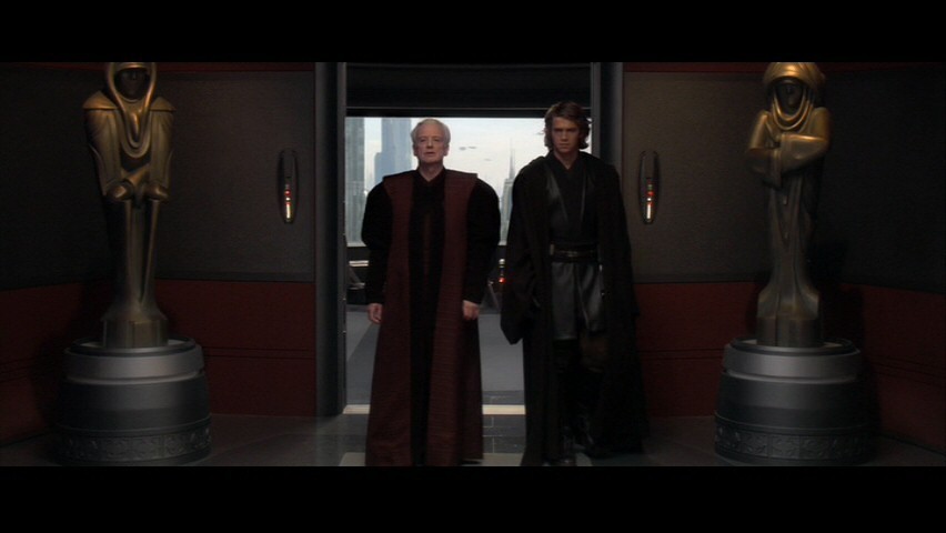 To the left is the Sith lord Sidious who turns the Jedi on the right to the "dark side". Notice the statues in the background both have their left arms over their right. This is used by demons (instead it is right over left for those of the light). It signifies the "left-handed path".